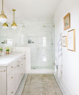 White drawers. white tile shower, gold hang lights