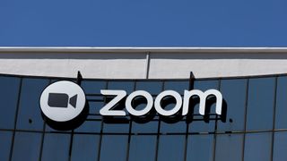 The Zoom logo on a glass building, with blue sky above