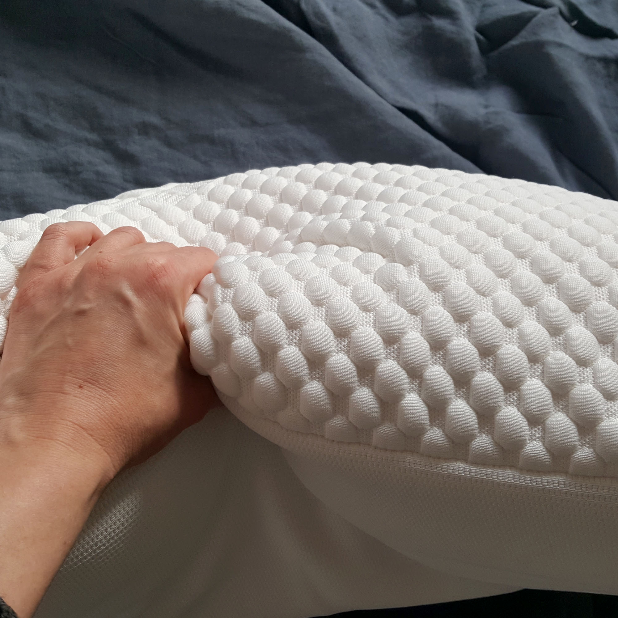 The Tempur Comfort Cloud pillow being tested on a bed with grey bedlinen
