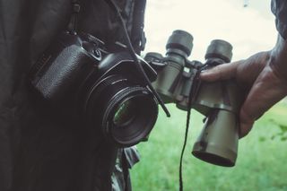 Digital camera and binoculars being used outside