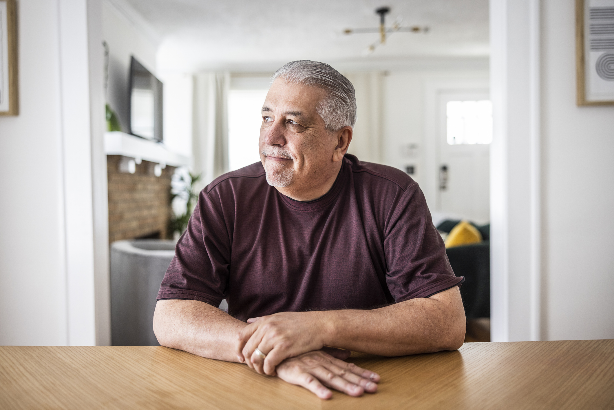 A man is sitting at a table thinking about his finances.