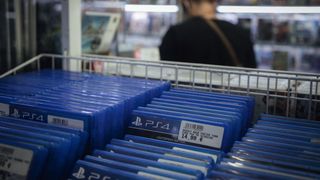 A customer browses products near copies of PlayStation 4 (PS4) games at a video games store.