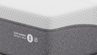 A close up of the Sleep Number i8 with grey base and white brand logo.