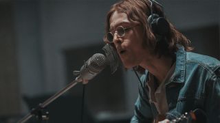 Harris Dickinson with long hair and glasses, as John Lennon