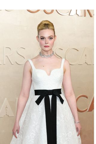 A photo of Elle Fanning accessorizing with a vintage Cartier necklace on the Oscars red carpet.