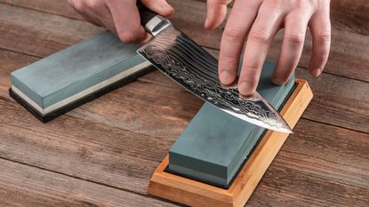 Someone sharpening a knife with a whetstone