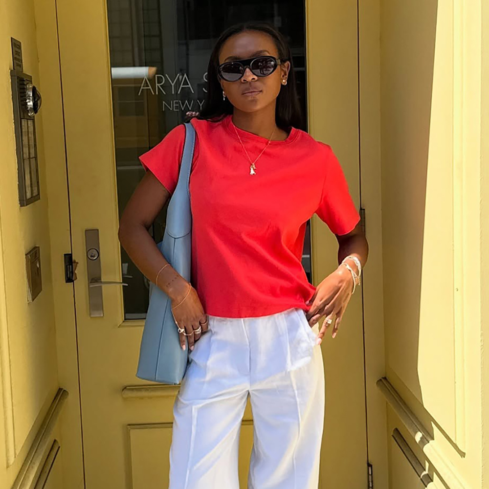 a woman wearing a red t-shirt, white pants, and red flats