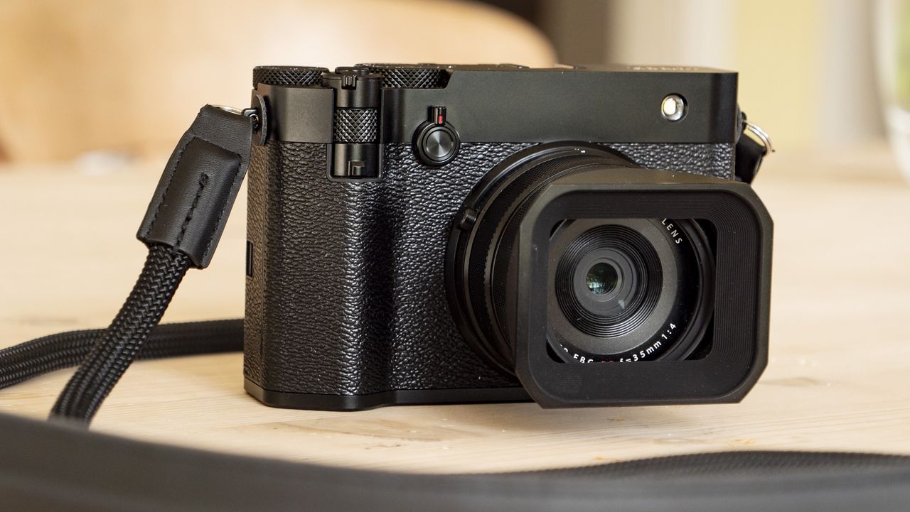 All-black Fujifilm GFX100RF rangefinder-style camera on a wooden table