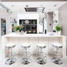 white kitchen with silver bar stool and white flooring