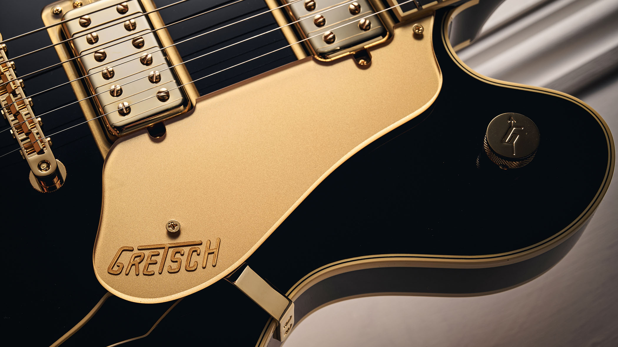 Gretsch Professional Collection Broadkaster LX Center Block: the handsome semi-hollow is finished in black with gold hardware and here is photographed in close-up.