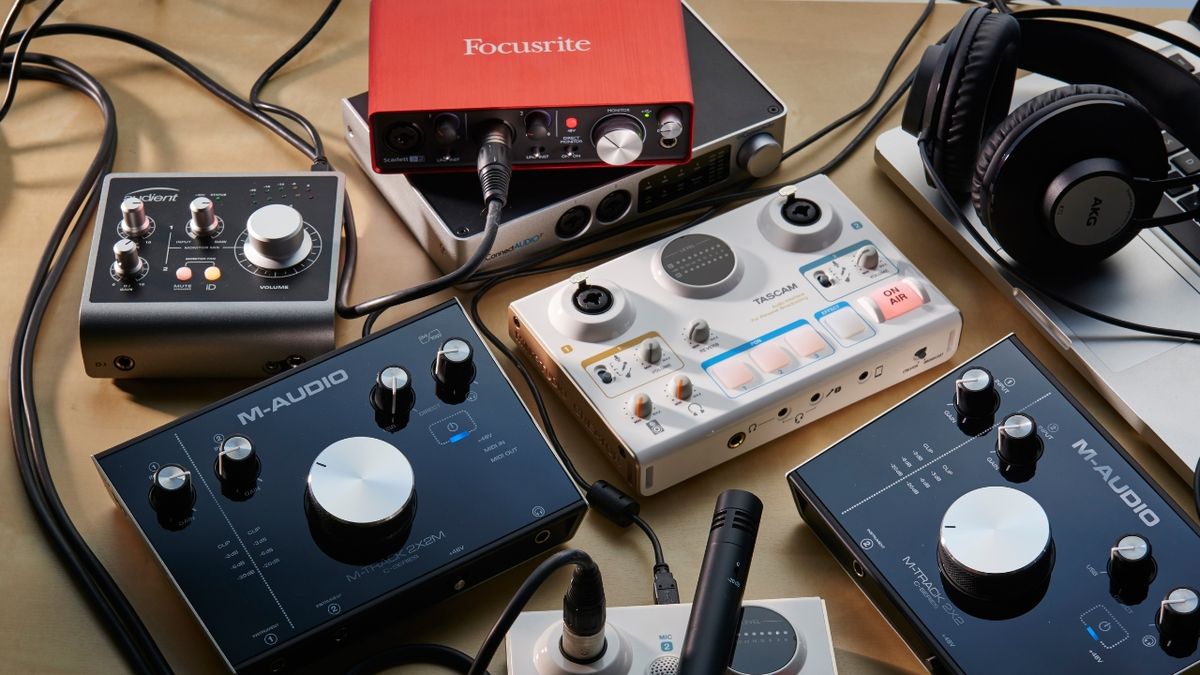 Various audio interfaces lying a wooden table