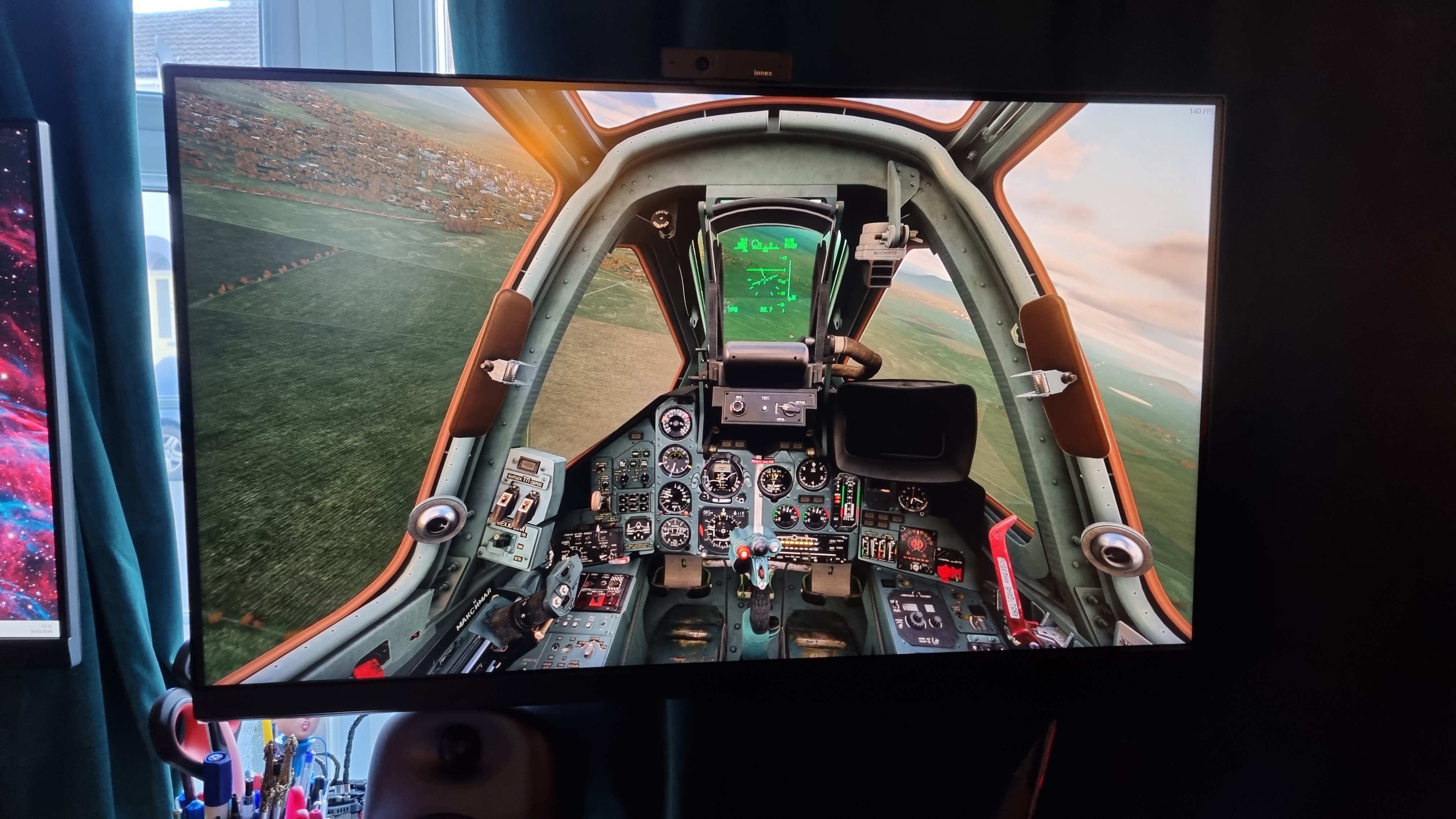 A photo of a 32-inch monitor displaying DCS World, with a jet fighter cockpit soaring above... Georgia? I forget