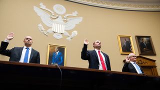 Three men in suits raise their right hands under a seal of the U.S. government. This photo was taken at the UFO hearing on July 26, 2023.