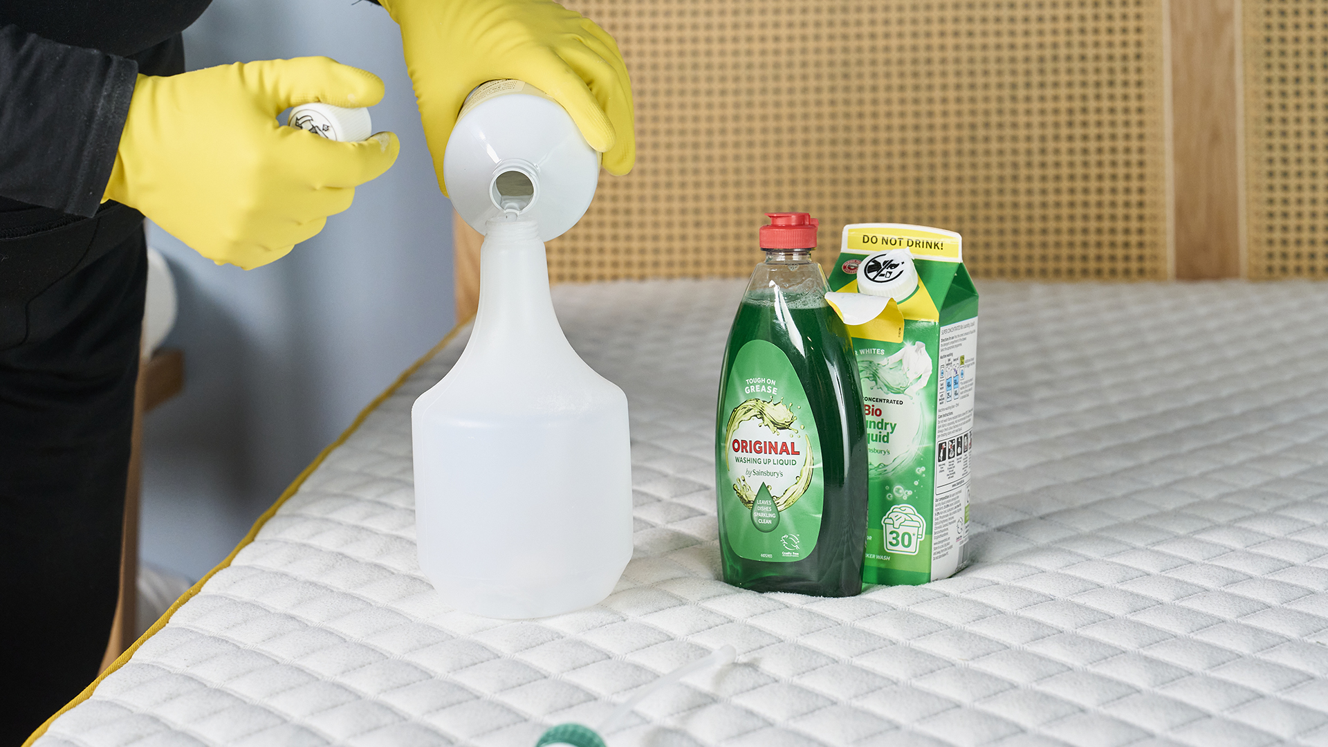 A woman mixing a solution of soap and laundry detergent to clean a mattress