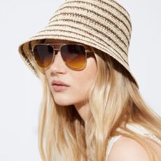 Blonde woman wearing striped hat and dark sunglasses