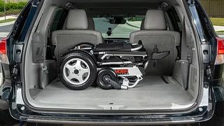 An image showing the Porto Mobility Ranger Quattro folded up and placed inside the trunk of a black car