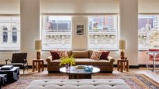 A large open plan living room with a sofa, a Persian style rug, and a round coffee table