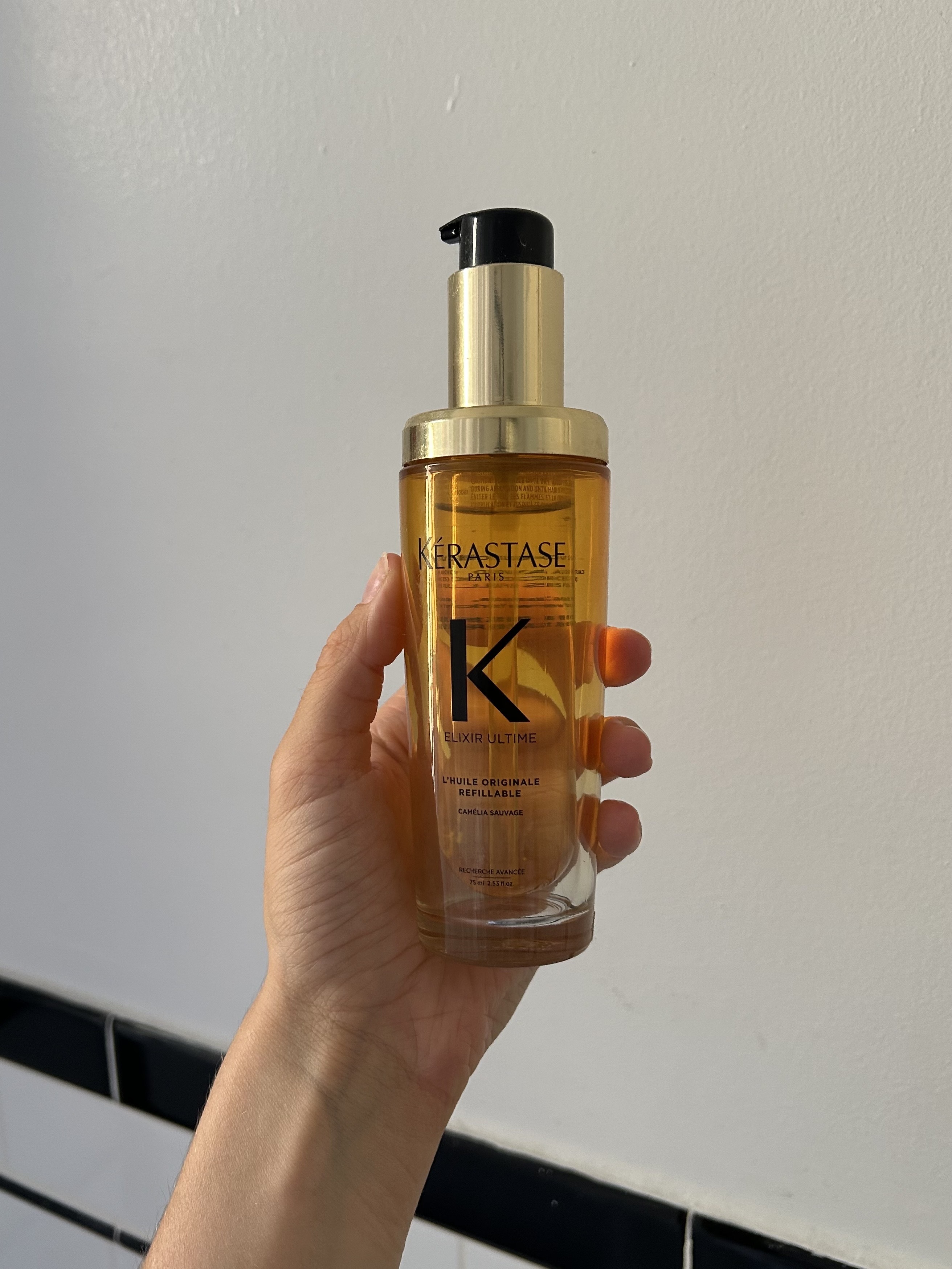 Alyssa Brascia holding the Kérastase Elixir Ultime Hydrating Hair Oil.