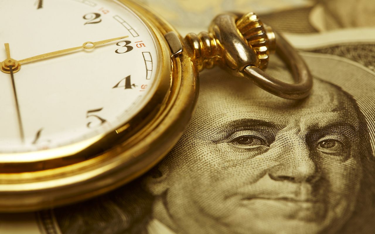 Macro shot of pocket watch face with 100 dollar bill Ben Franklin. Selective focus is on Franklin&amp;#039;s Eyes. Gold Tone.