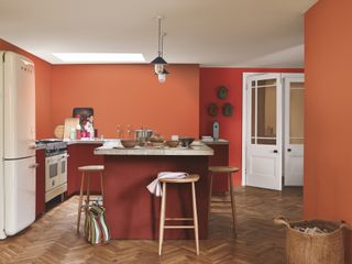 terracotta kitchen, herringbone floor, white fridge, white double doors, bar stools, kitchen island, basket