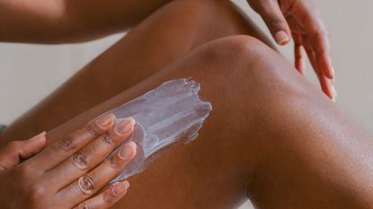 a woman rubbing a best body cream for dry skin Getty Images 1653185592 