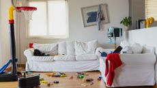 A cluttered living room with children's toys strewn about. 