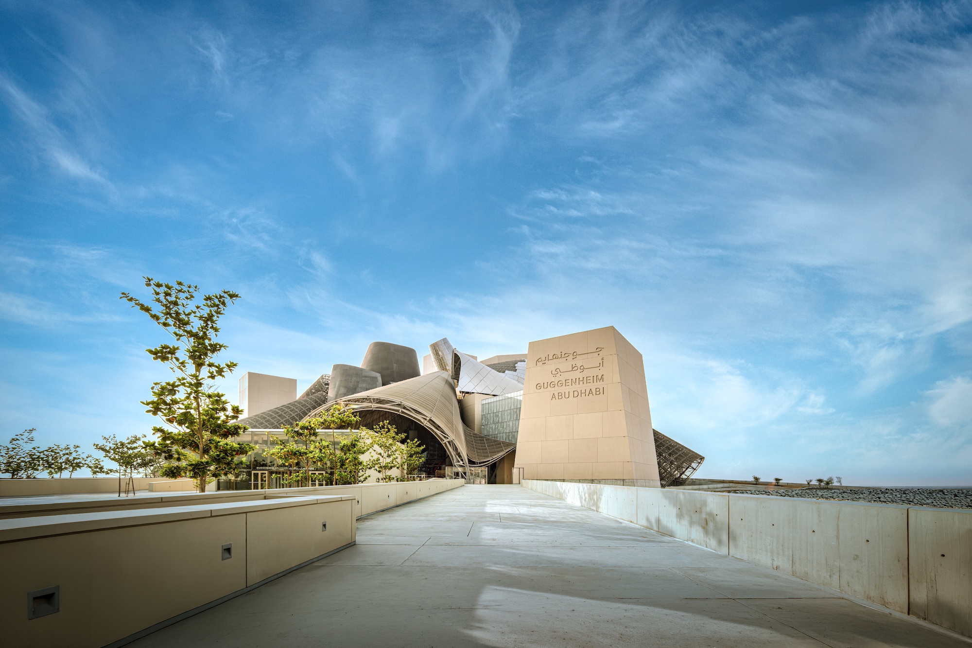 Guggenheim Abu Dhabi exterior images featuring a geometric assemblage of volumes made from steel glass timber and stone