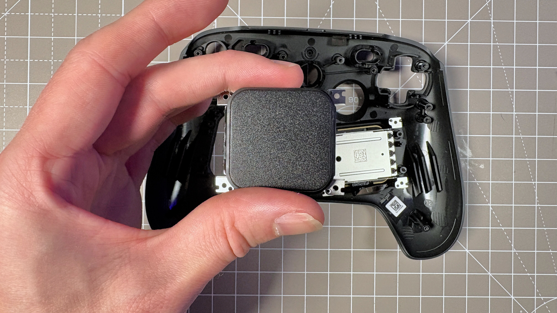 The Steam Controller on a desk during a teardown, with various parts removed.