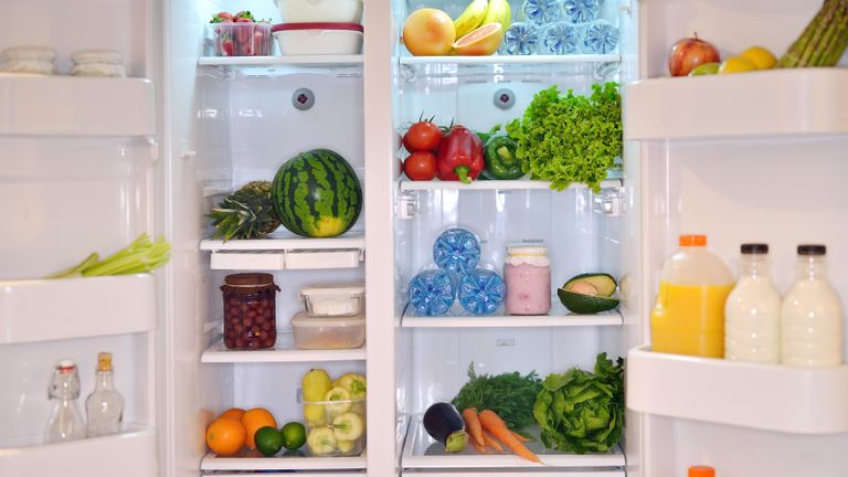 A well-stocked fridge with fruit, veg and bottles