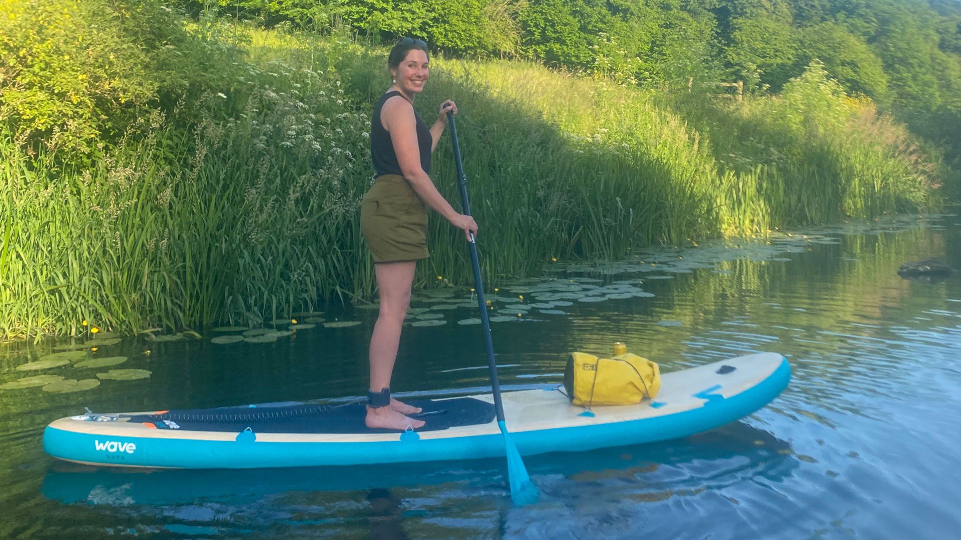 Woman stand-up paddle boarding on the Wave Woody SUP package