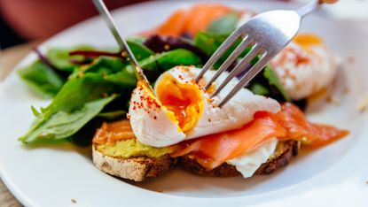 Slice of bread topped with smoked salmon, spinach and a poached egg