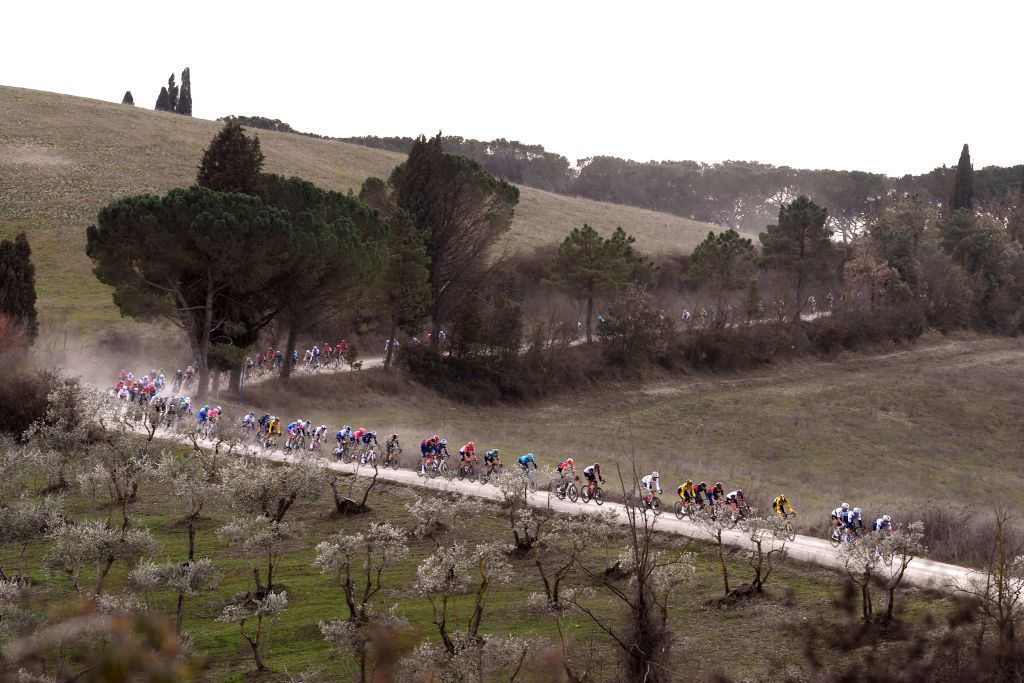 SIENA ITALY MARCH 05 The peloton passing through a gravel strokes sector during the Eroica 16th Strade Bianche 2022 Mens Elite a 184km one day race from Siena to Siena Piazza del Campo 321m StradeBianche WorldTour on March 05 2022 in Siena Italy Photo by Tim de WaeleGetty Images