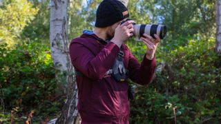 Cotton Carrier Skout G2 worn by a man in a burgandy jacket outdoors in a woods