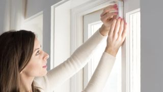 Abode door and window sensor being installed on a door