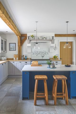 country farmhouse kitchen with light and dark blue cabinets and grey flooring