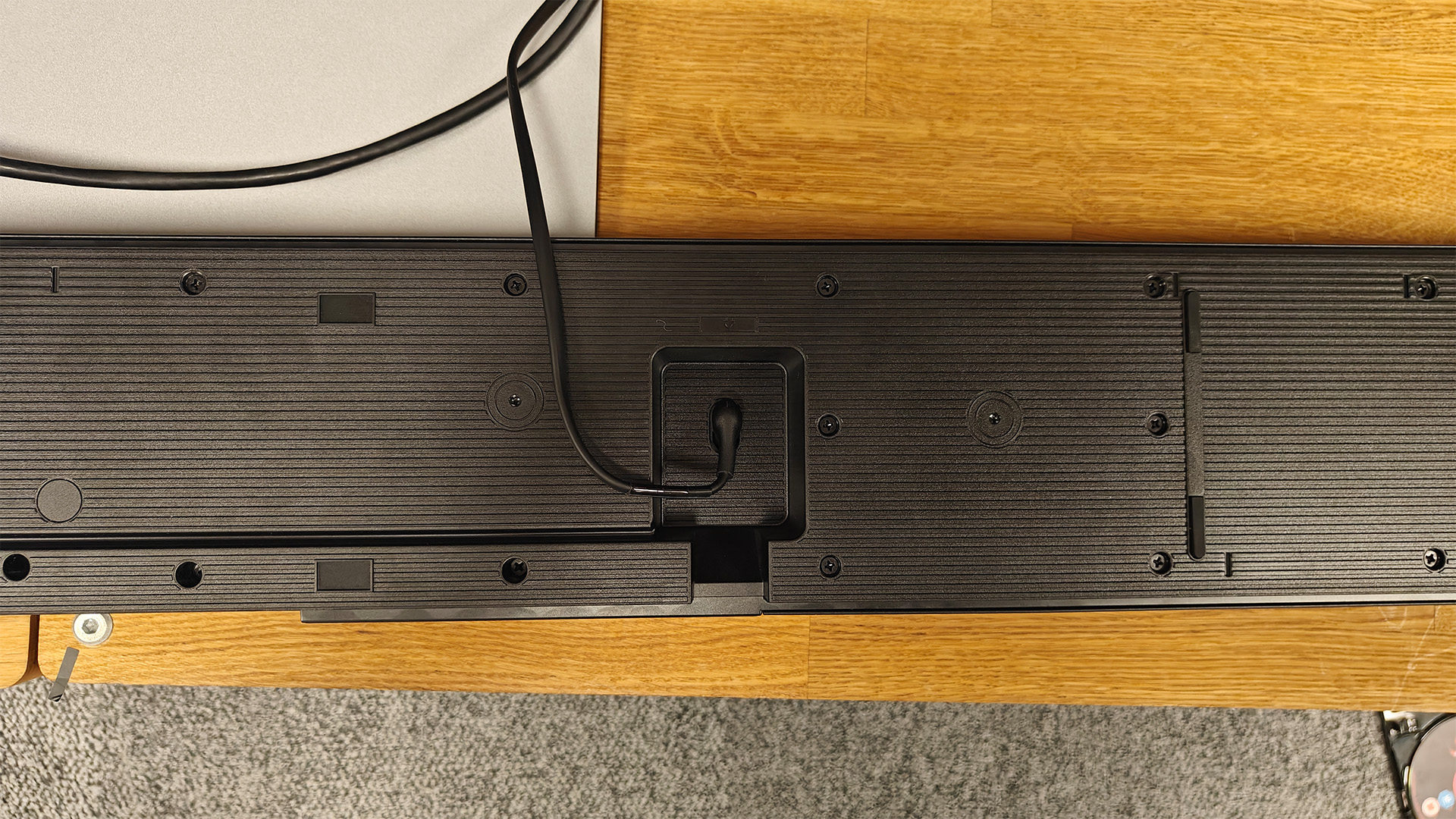 Samsung HW-QS90H Dolby Atmos soundbar upside down on wooden AV rack