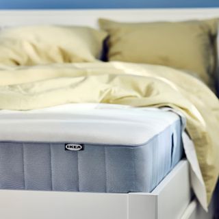 Yellow duvet and cushion on the VESTERÖY mattress. 