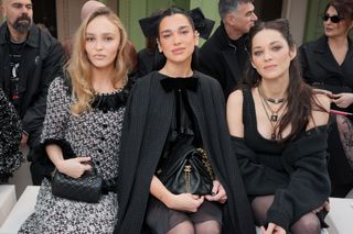 A photo of Dua Lipa sitting front-row with actors Lily-Rose Depp and Marion Cotillard.