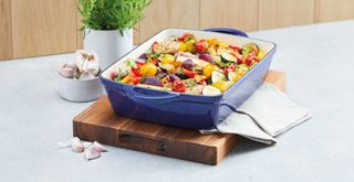 Midnight Blue Aldi cast iron roaster dish with cooked vegetables