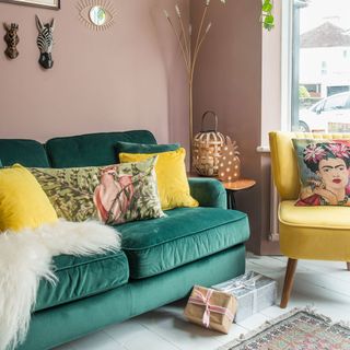 living room with pink wall and green sofa