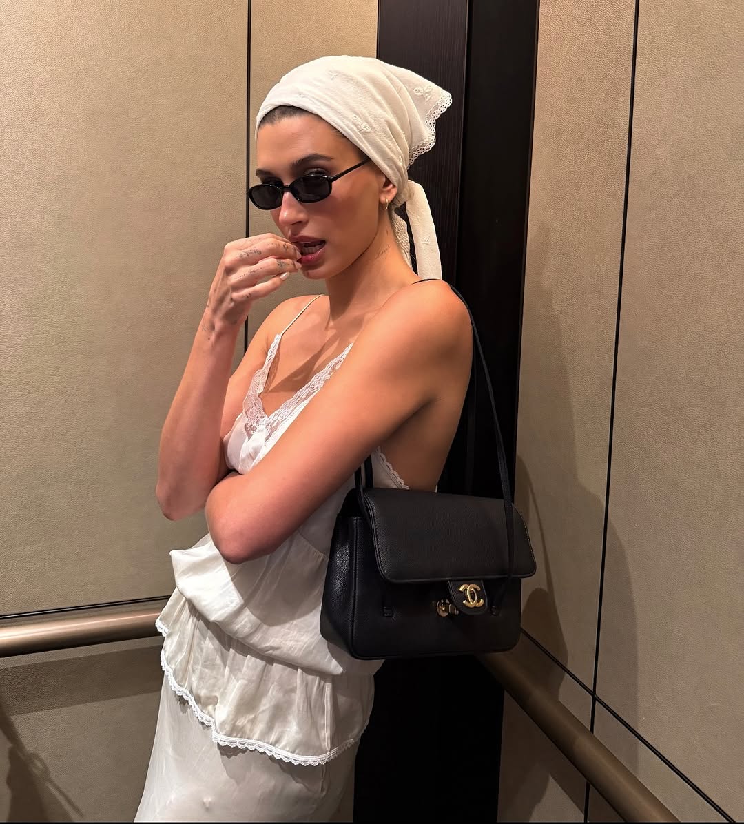 Hailey Bieber styled a lace lingerie-inspired skirt set from Magda Butrym with the triangle hair scarf trend and a new Chanel bag