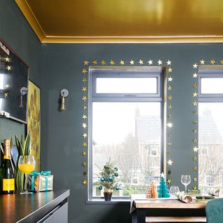 black kitchen with gold ceiling and windows