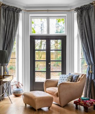 Large window curtain ideas with dary grey curtains in a bay window with a French door at the center