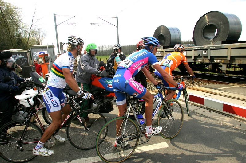 Tom Boonen, Alessandro Ballan and Juan Antonio Flecha wait for the train to cross in 2006