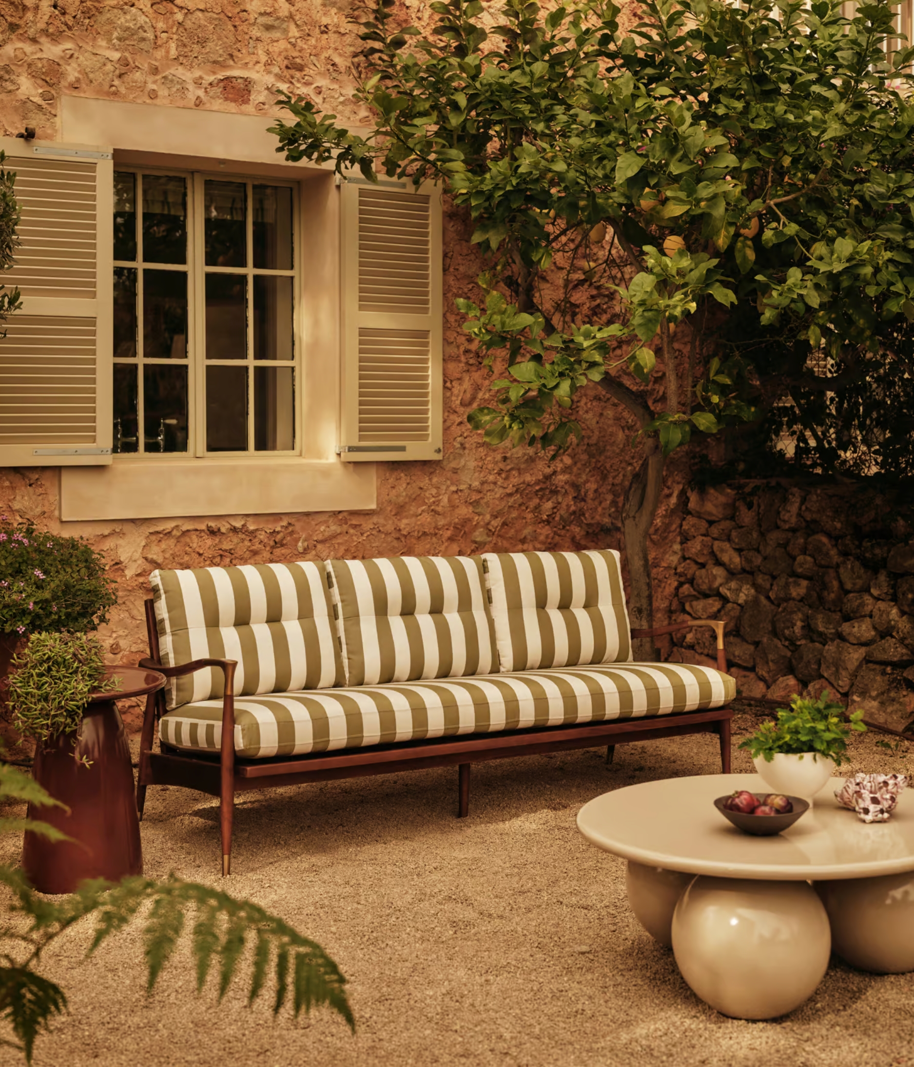 a striped outdoor sofa in a mediterranean look garden