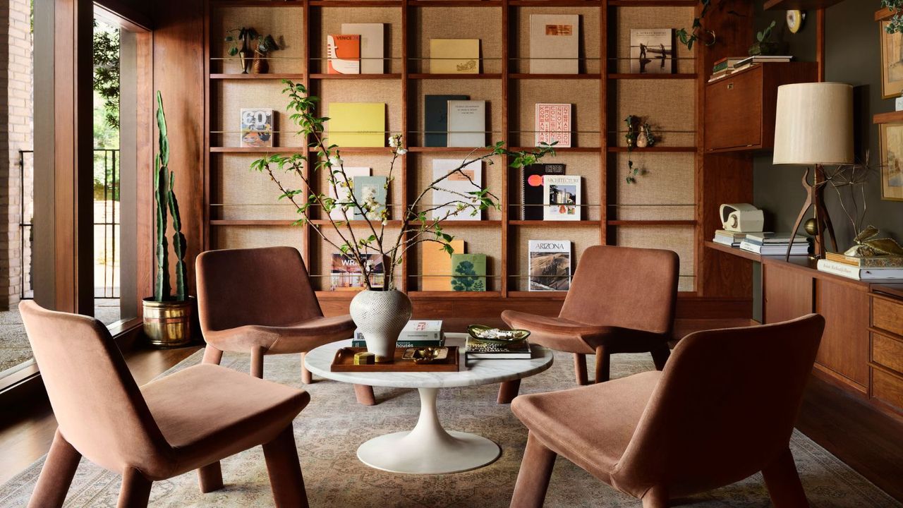 A mid-century modern library with four chairs and a wall of display books