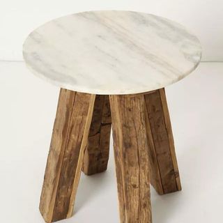 A wooden side table with a marble top