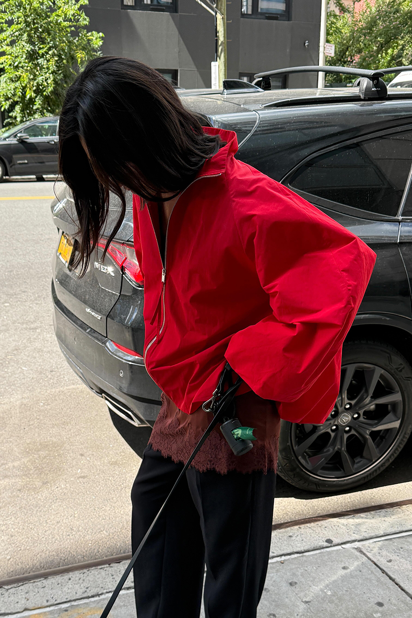 a woman wearing a red jacket and black pants