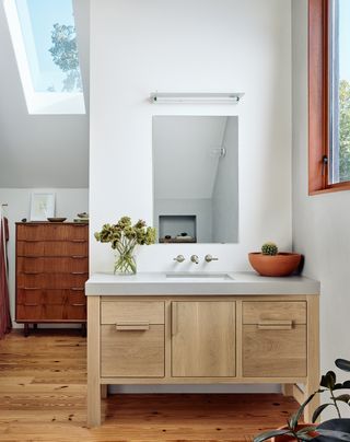 Bathroom basin and wood cabinet with plants on