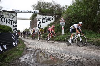 Alpecin - Deceuninck team's Dutch rider Mathieu Van Der Poel (R) leads the pack of riders past the Pont Gibus at cobblestone sector 18 during the 121st edition of the Paris-Roubaix one-day classic cycling race, 260km between Compiegne and Roubaix, northern France, on April 7, 2024. (Photo by Anne-Christine POUJOULAT / AFP)